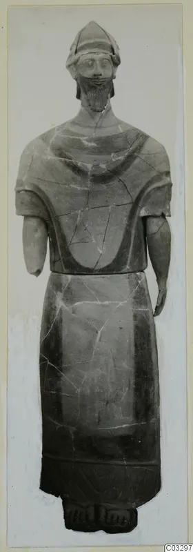 Terracotta statue of a standing bearded figure in a helmet-like cap, with short arms and painted bands on the body