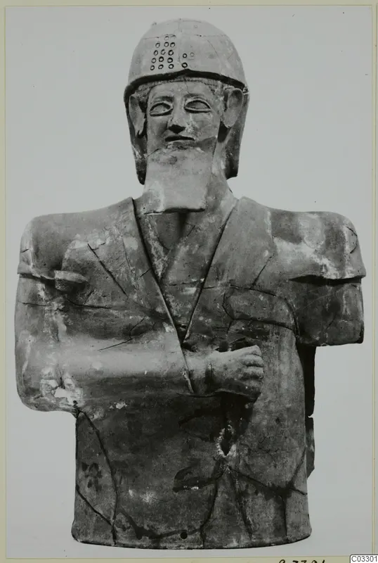 Terracotta bust of a bearded male figure in a helmet, arms folded across the chest