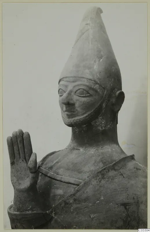 Terracotta Proto-Cypriote II: head and upper body of a terracotta statue with a tall conical headdress and raised hand