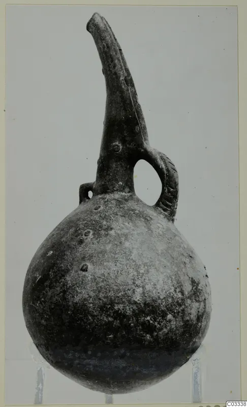 Red Polished III jug from the Vrysi tou Barba tombs at Lapithos, with a tall spout and strap handle