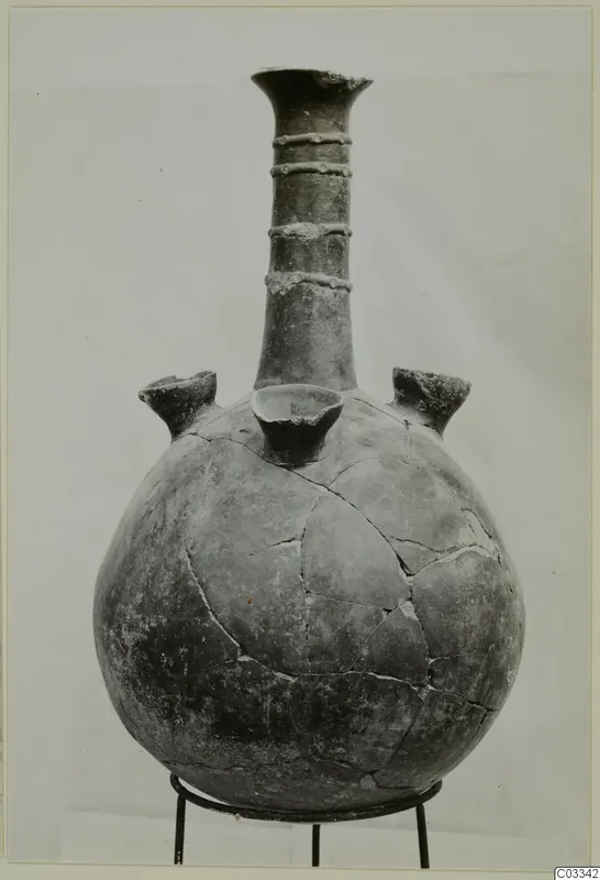 Red Polished II jug with a tall neck, three raised knobbed bands on the neck and three spouts on the body