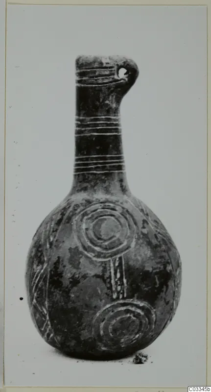 Black polished vessel with a long neck, incised grooves and concentric circles on the body