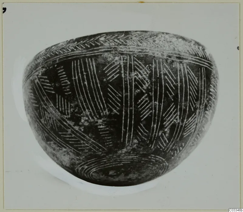 Red Polished III bowl with incised chevron and line decoration, photographed against a pale background