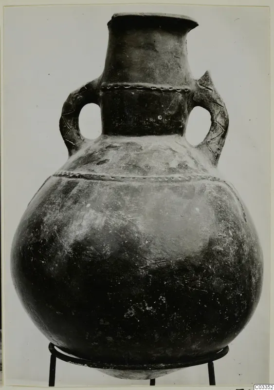 Pottery Red Polished III amphora with two loop handles, shown on a wire stand against a plain grey background