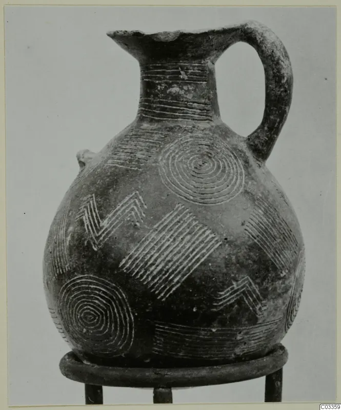 Pottery Red Polished II jug with incised concentric circles, zigzags and hatched bands, standing on a metal ring stand