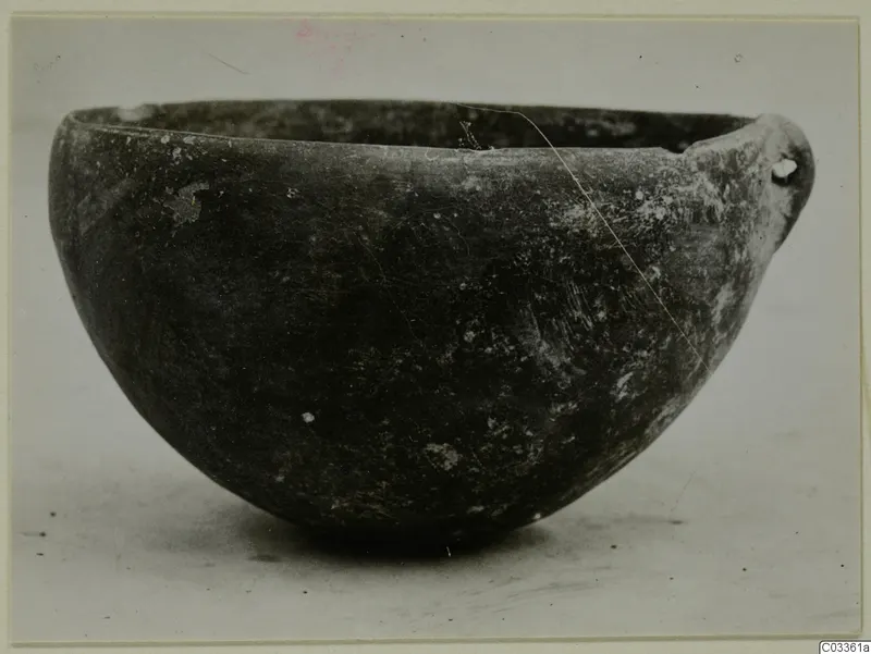 Pottery Red Polished III Bowl from Lapithos, shown in side view against a plain pale background