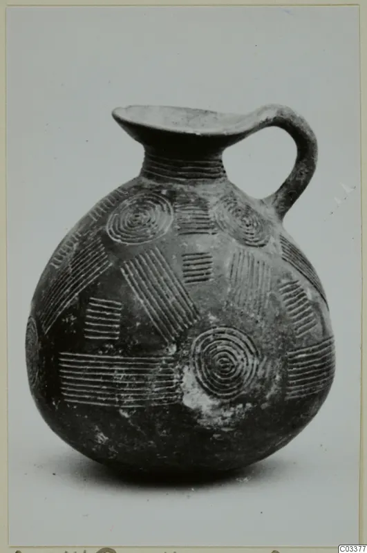 Pottery Red Polished II jug with a strap handle and incised concentric circles and parallel lines