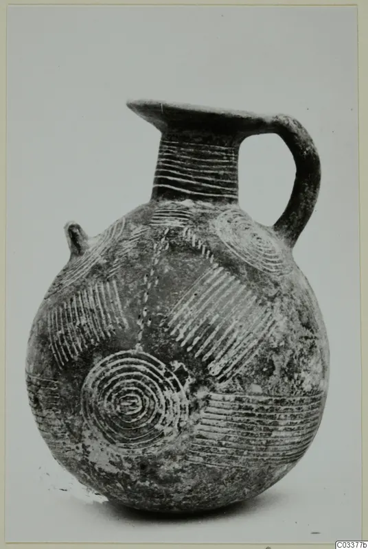 Pottery Red Polished II jug with a strap handle, a small lug and incised concentric circle and line decoration