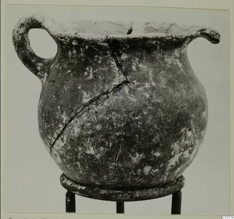 Pottery Red Polished III jug from Lapithos, with a single loop handle and a crack down its body