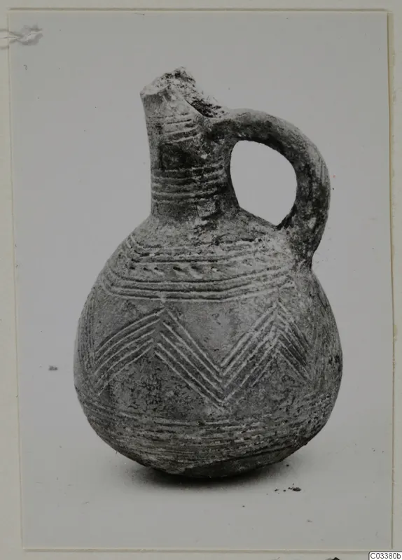 Pottery Red Polished III jug with a loop handle and incised band and chevron decoration