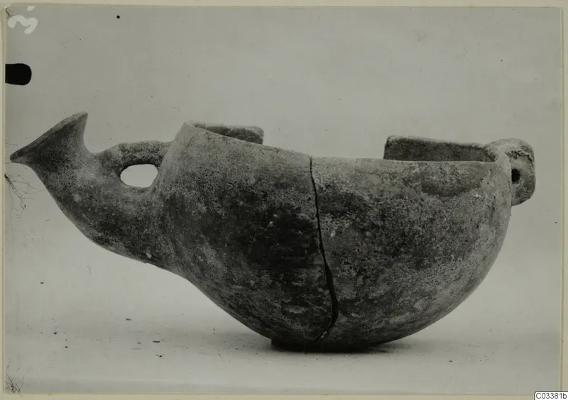 Red Polished III bowl from Lapithos with a pointed projection, loop handle and raised lugs, seen from the side.