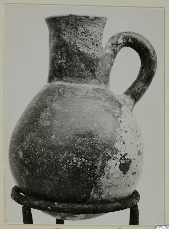 Red Polished III jug from Lapithos, Vrysi tou Barba tombs, standing on a metal ring stand