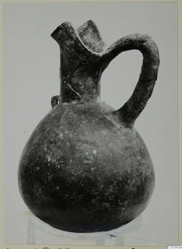 Pottery Red Polished III jug with a rounded body, flared spout and strap handle