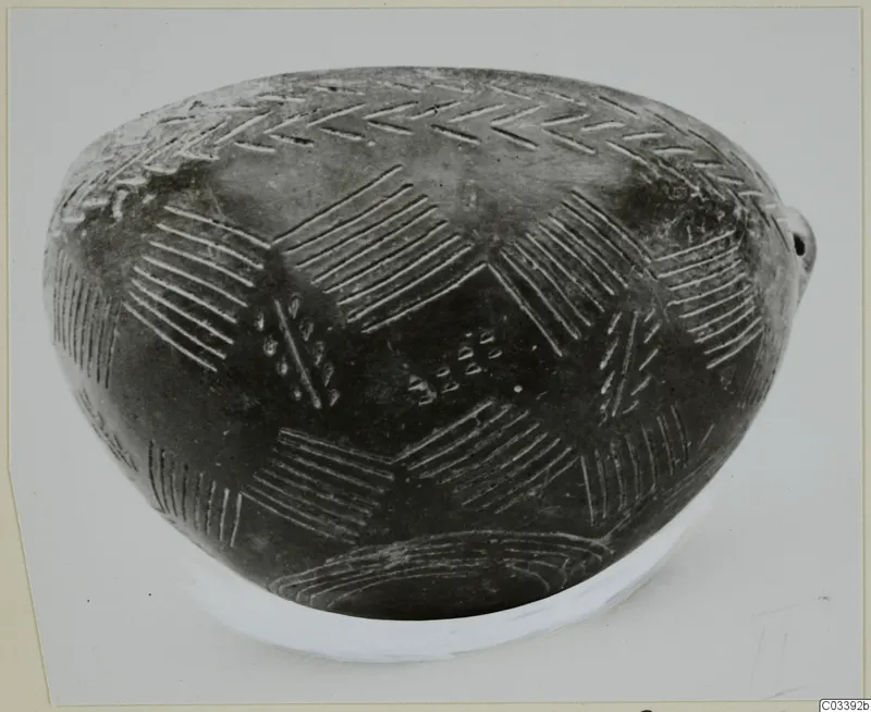 Pottery Red Polished III bowl from Lapithos with incised chevron and hatched patterns on a dark surface.