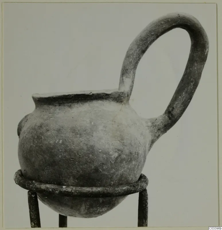Pottery vessel with a single loop handle on a metal stand, find from the Vrysi tou Barba tombs at Lapithos