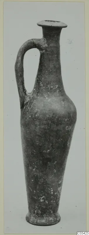 Pottery jug in Red Lustrous Ware with a single handle and flared rim, photographed against a pale background.