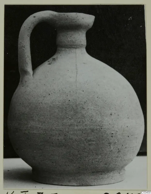 Pot with a single handle from Kountoura Trachonia, photographed against a dark background.