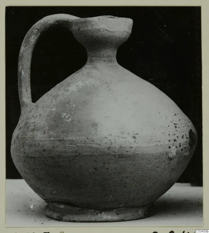 Pottery jug with a single strap handle and a wide, rounded body.