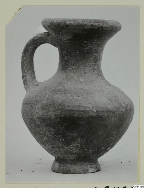 Pottery jug with one handle, a flared mouth and a rounded body, photographed against a pale background.