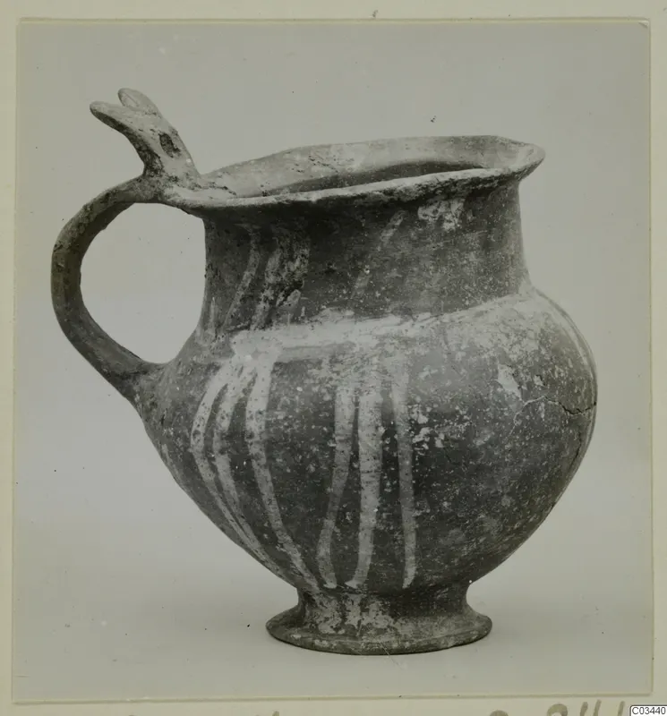 Base-Ring ware jug with a trefoil-type spout, a loop handle and white painted vertical stripes on the body.
