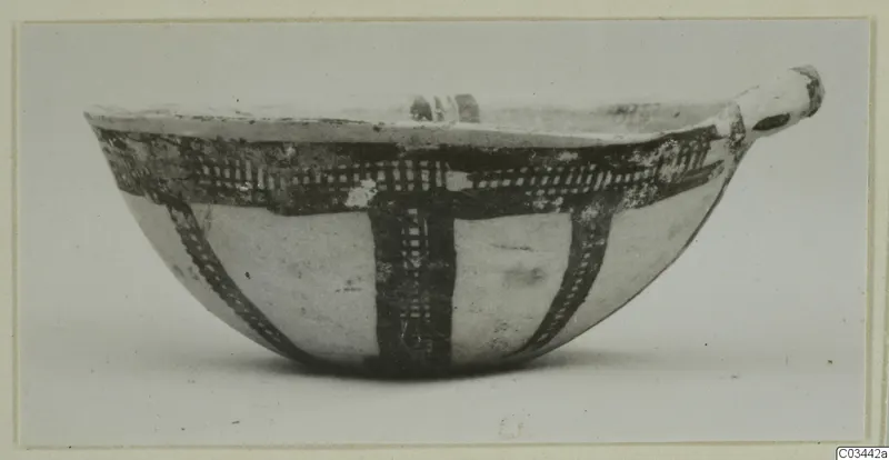 Pottery White Slip Ware bowl with dark cross-hatched painted bands and a small handle