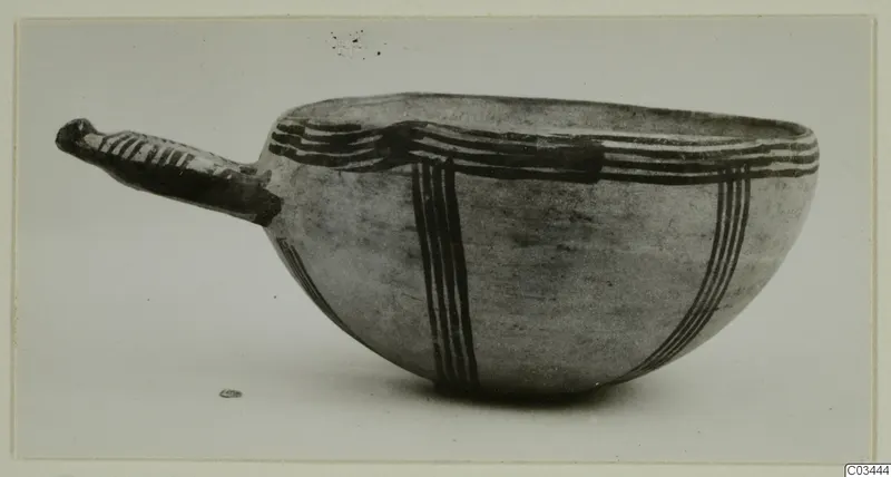 Bowl with a long handle and dark painted bands on a pale surface, photographed in side view