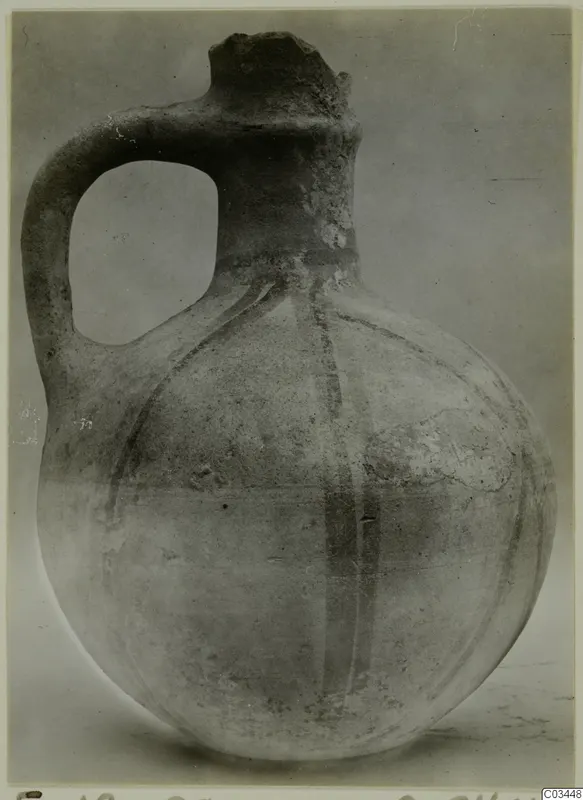 Round-bodied jug with a single loop handle and a tall neck, with dark painted bands on its body.