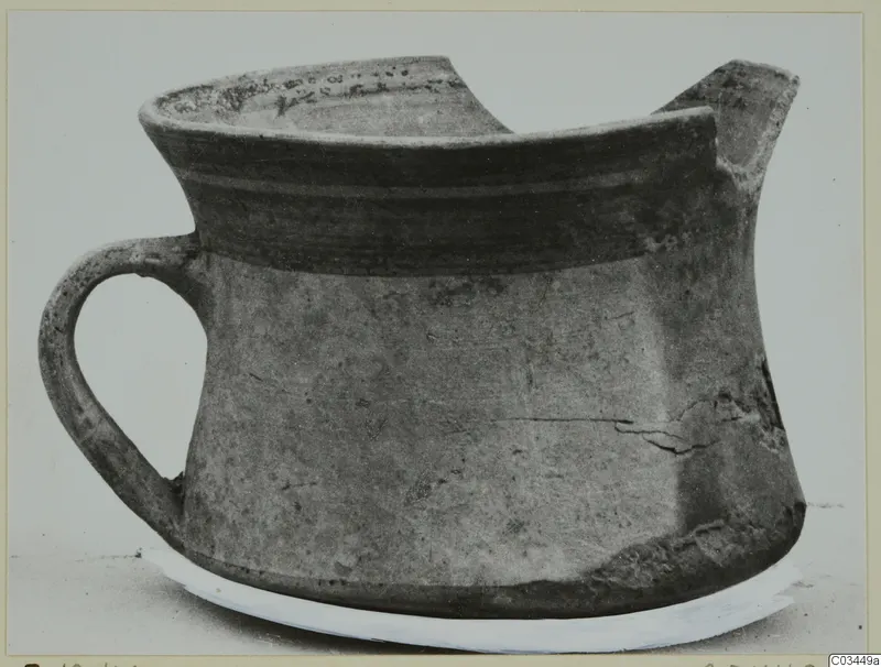 Pottery bowl-jar from Enkomi with a strap handle and a spout, shown from the side.