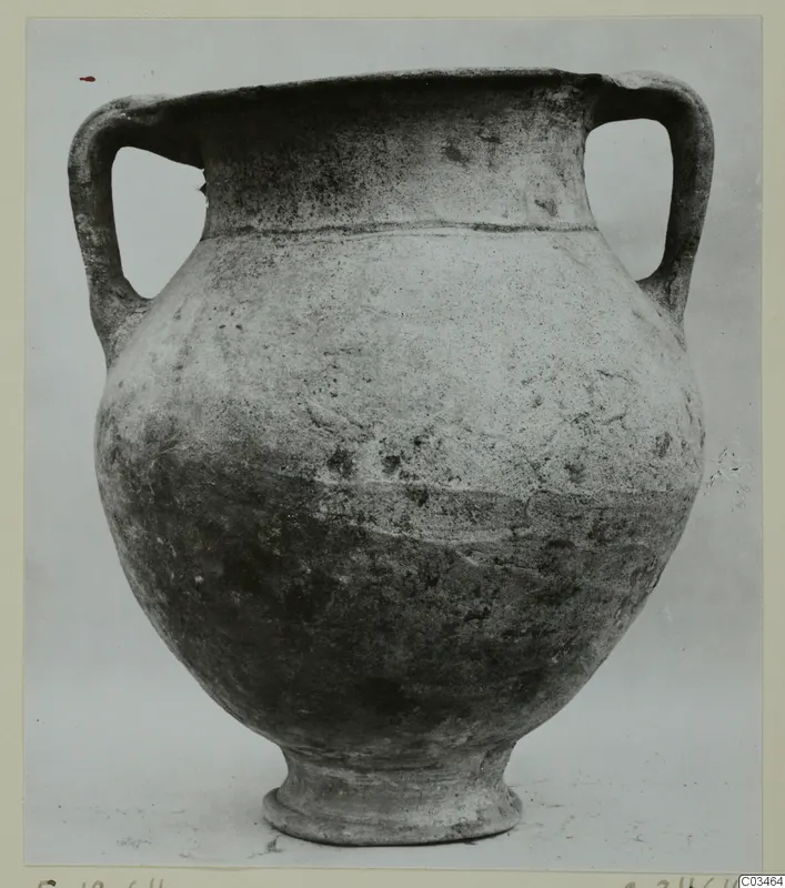 Plain white wheel-made pottery jar with two loop handles and a footed base, photographed against a plain grey background.