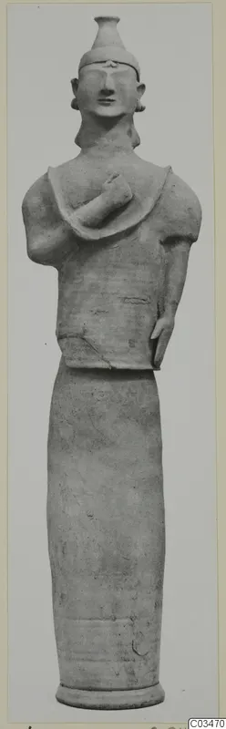 Terracotta standing figure with a tall headdress and one arm bent across the chest, from Ayia Irini