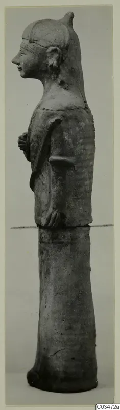 Terracotta statue of a standing female figure in profile, facing left, on a tall cylindrical base.