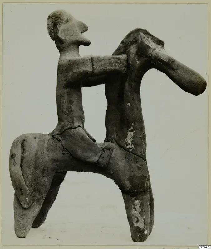 Terracotta figurine of a human figure seated on a four-legged animal
