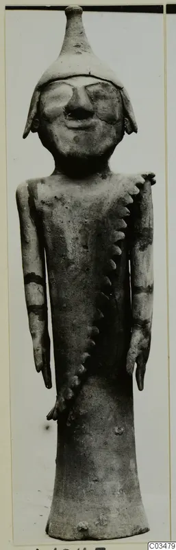 Terracotta figurine of a standing figure with a tall conical headdress and a notched applied strip across the body