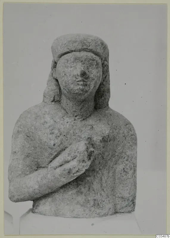 Limestone bust of a woman with her right hand resting on her chest, head covered by a band.