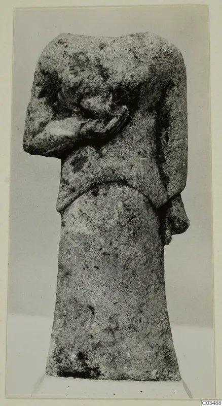 Limestone sculpture of a head on a tall, tapering base, with a long nose in profile