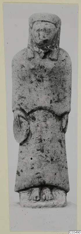 Limestone statue of a standing figure in a long robe and close head covering, hands at the body, on a rectangular base