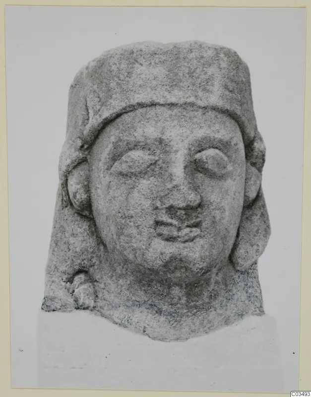 Limestone Proto-Cypriote head, front view, with a flat-topped headdress and hair falling to the shoulders