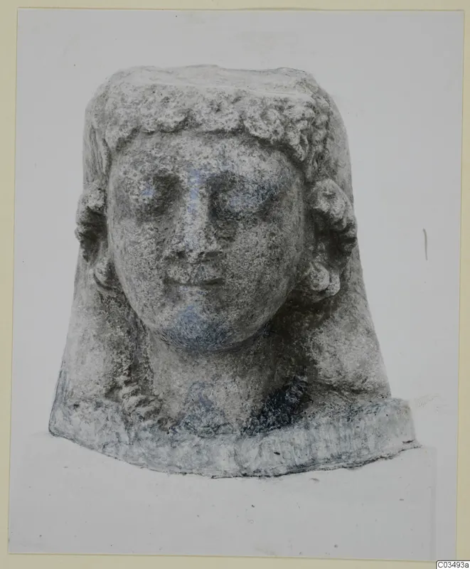 Limestone sculpture of a head with curled hair and a flat-topped crown, shown from the front