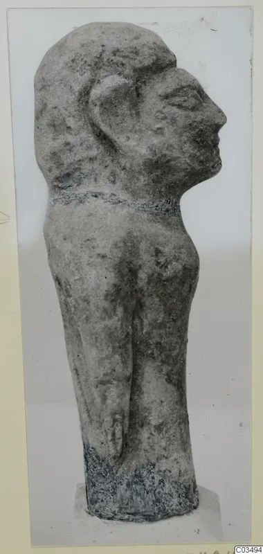 Limestone figure in side profile facing right, with a band around the neck