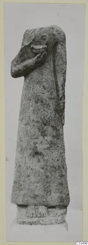 Limestone statue of a standing figure with one arm raised towards the face, on a rectangular base