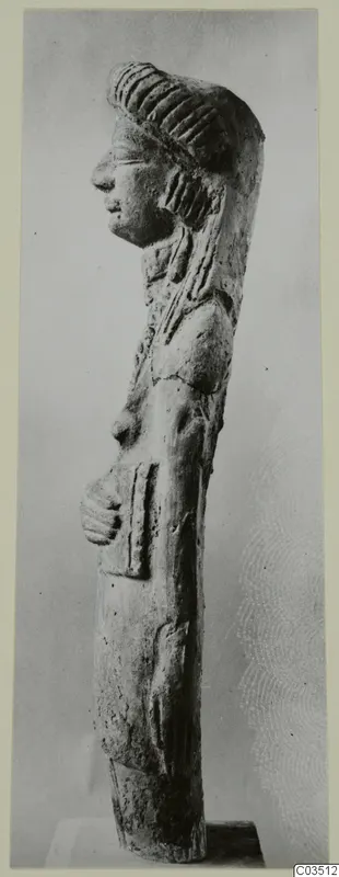 Terracotta figure seen in profile, facing left, with ridged hair and one hand on its abdomen.