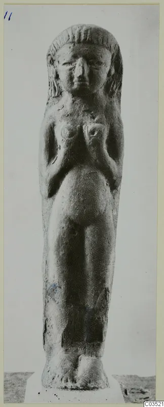 Standing female figurine with hands resting on its breasts and hair framing the face
