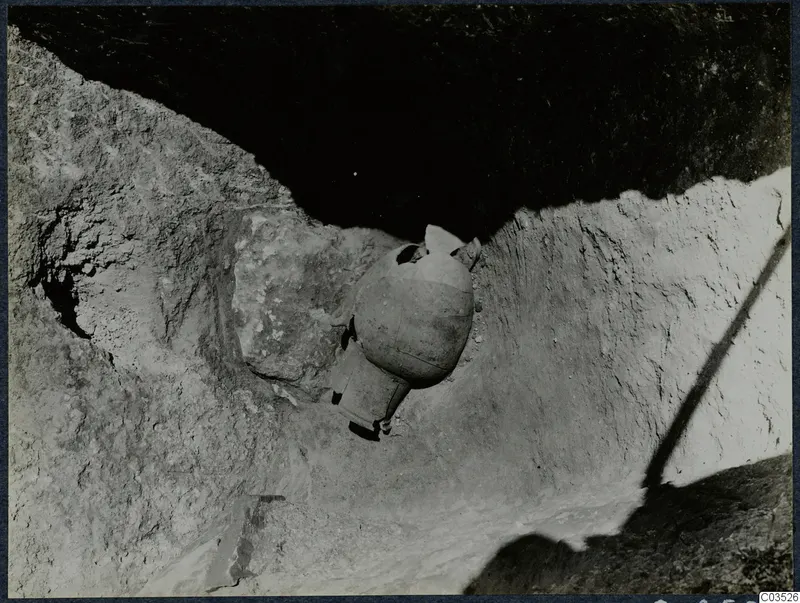 Pottery vessel in situ during excavation at Stylli, seen in a rock-cut trench