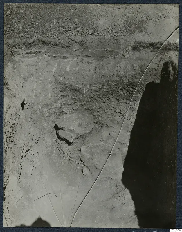 Excavation face at Stylli with horizontal layers of soil and large stones set into the earth