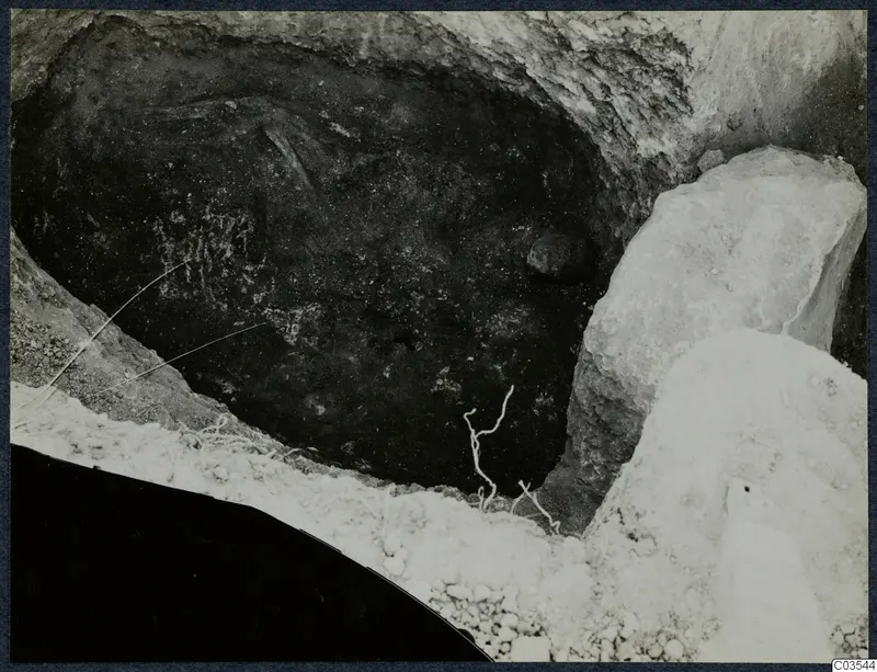 Excavation pit at Stylli with large pale stones at its edge