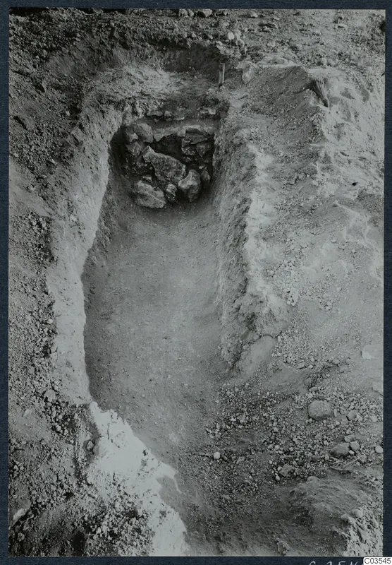 Excavation trench at Stylli with a cluster of stones in a recess at the far end