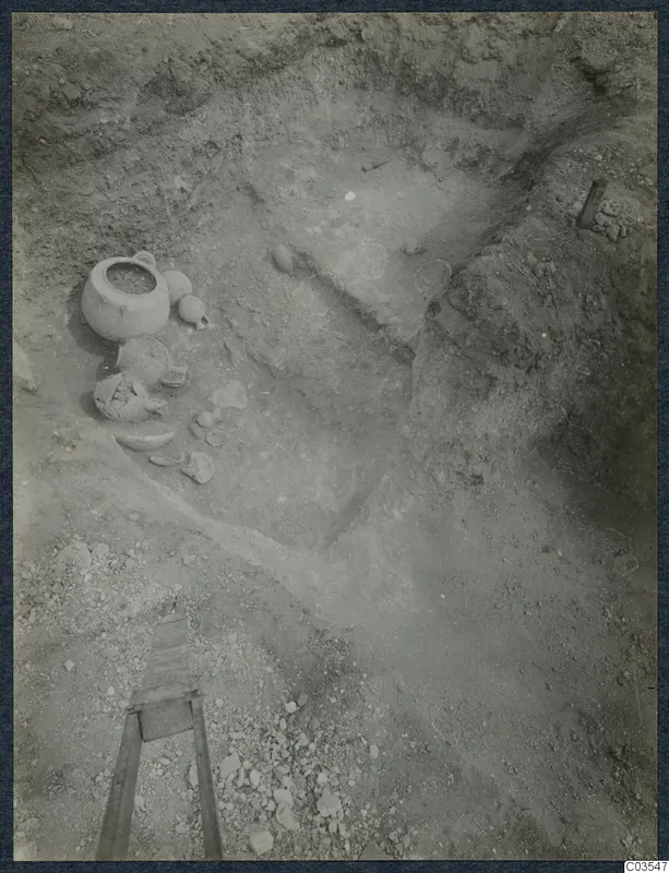 Excavation at Stylli with pottery vessels and broken sherds lying on the floor of a trench