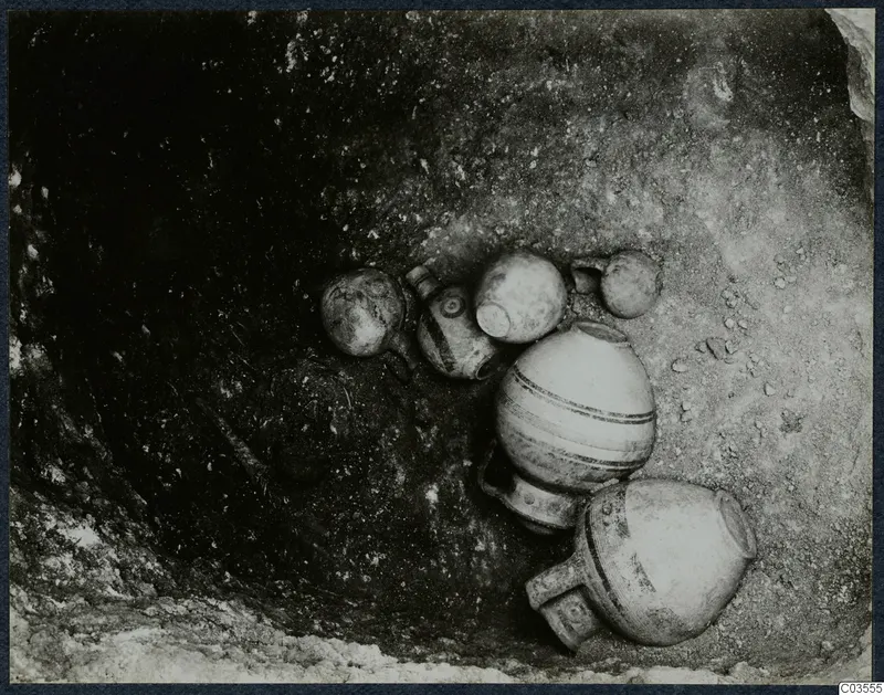 Several pottery vessels lying in situ in an excavated hollow at Stylli.