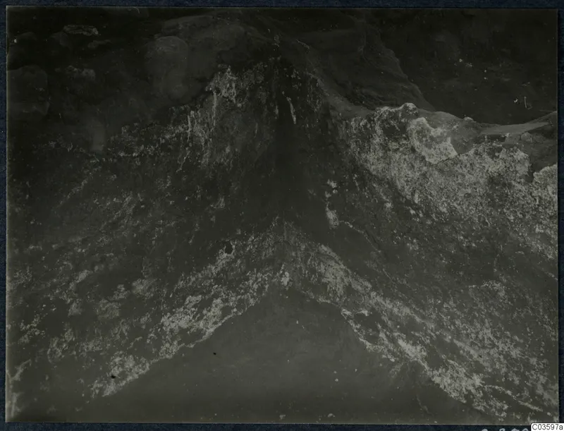 Close view of a rough stone surface with pale patches meeting at a V-shaped angle, Cholades, Soli