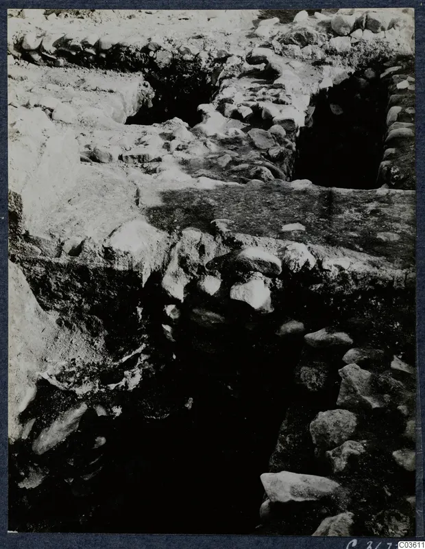 Excavation trench at Soli with exposed stone walls and a flat slab across the middle